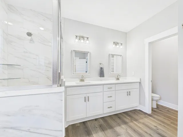 a spacious bathroom with a granite countertop sink a toilet mirror and bathtub