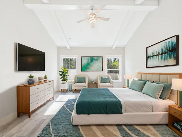 a spacious bedroom with a bed and a flat screen tv