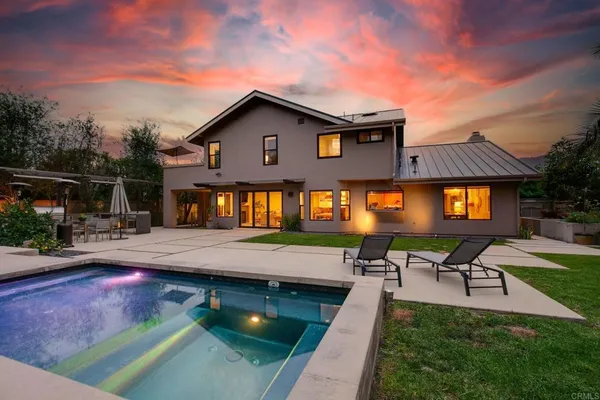 a view of a house with swimming pool and sitting area