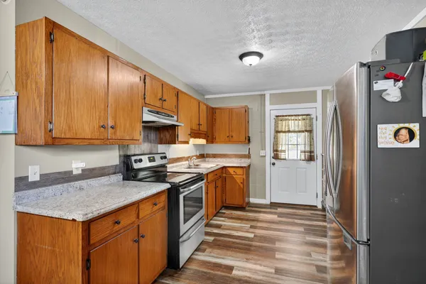 a kitchen with stainless steel appliances granite countertop a sink stove and refrigerator