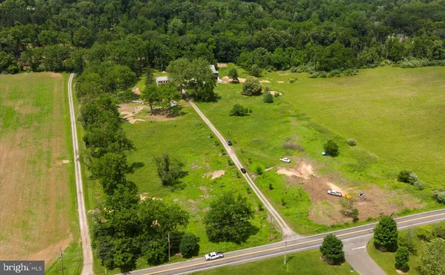 an aerial view of residential houses with outdoor space and trees