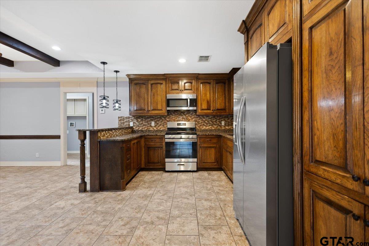 14733 County Road 384 Tyler, TX 75708 - Photo 24 of 38 a kitchen with stainless steel appliances a refrigerator and a stove