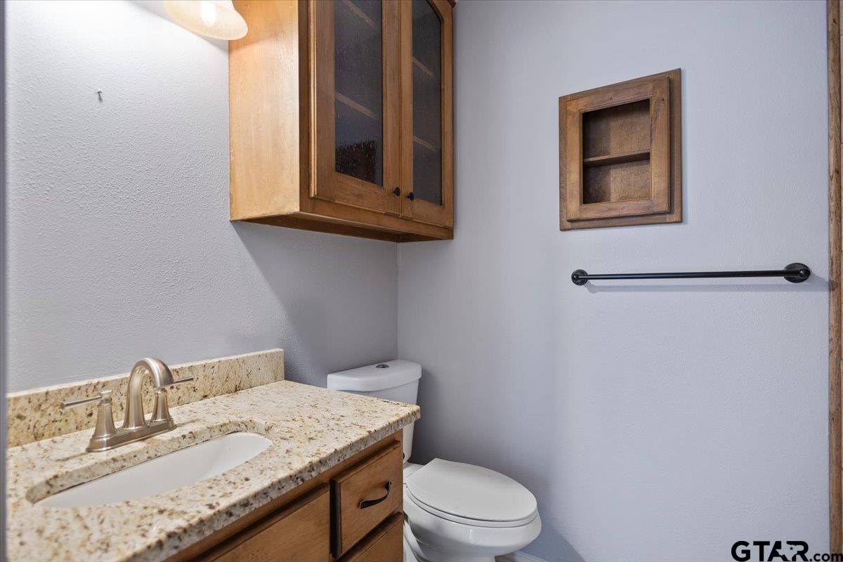 14733 County Road 384 Tyler, TX 75708 - Photo 6 of 38 a bathroom with a granite countertop sink mirror vanity and toilet