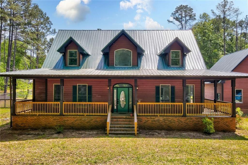 1206 Jasmine Road Dublin, GA 31021 - Photo 2 of 33 a view of a brick house with large windows and a yard with plants