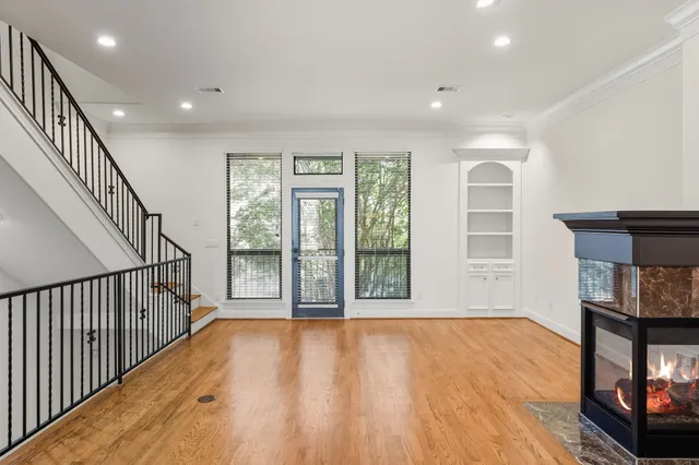 a view of a livingroom with wooden floor a fireplace and window