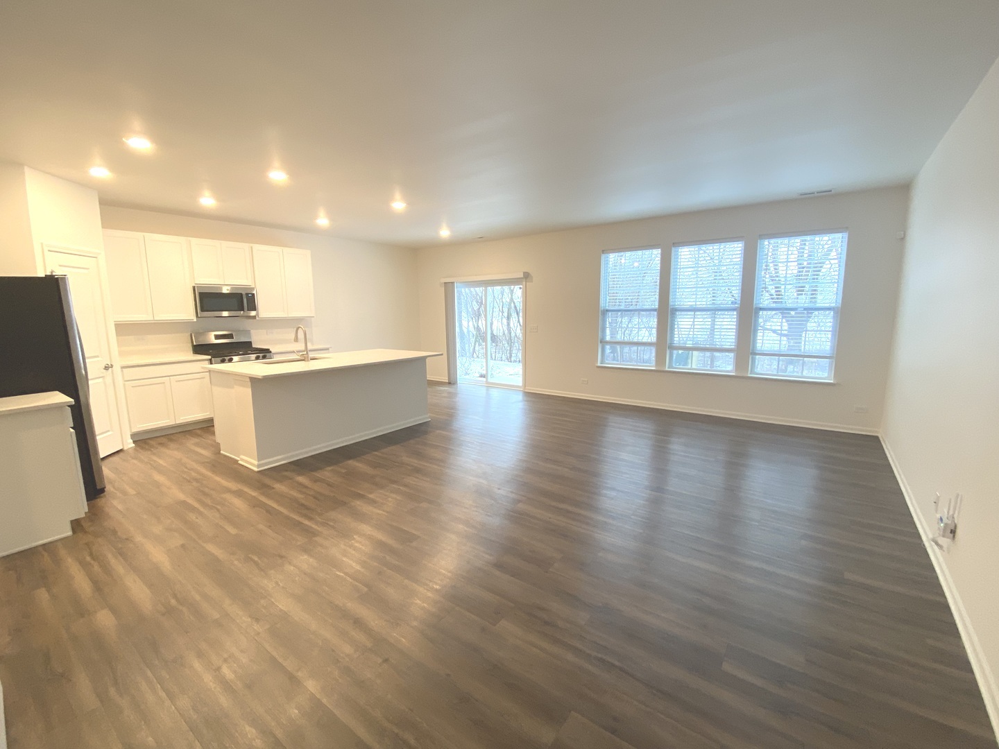 1009 North Draper Road McHenry, IL 60050 - Photo 3 of 20 a view of a kitchen and an empty room with wooden floor