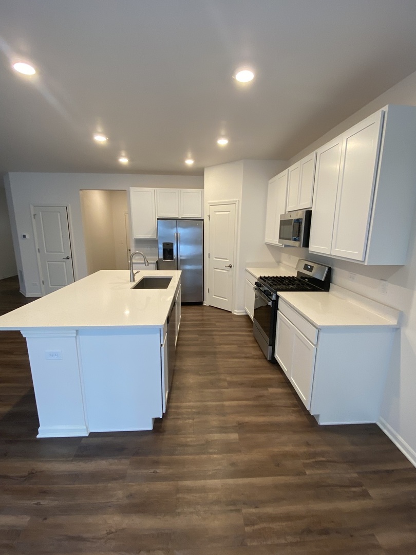 1009 North Draper Road McHenry, IL 60050 - Photo 6 of 20 a large kitchen with kitchen island a sink counter top space and cabinets