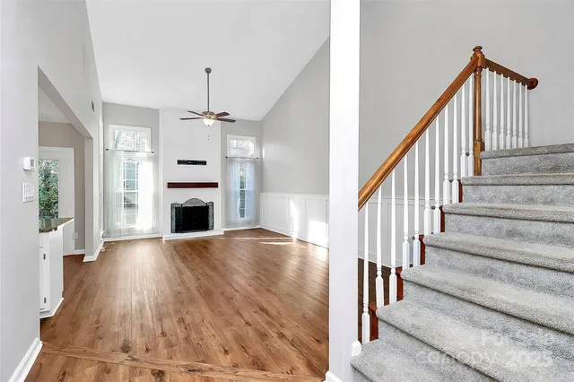 a view of a hallway with wooden floor and staircase