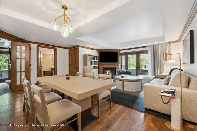 a view of a dining room with furniture a chandelier and wooden floor
