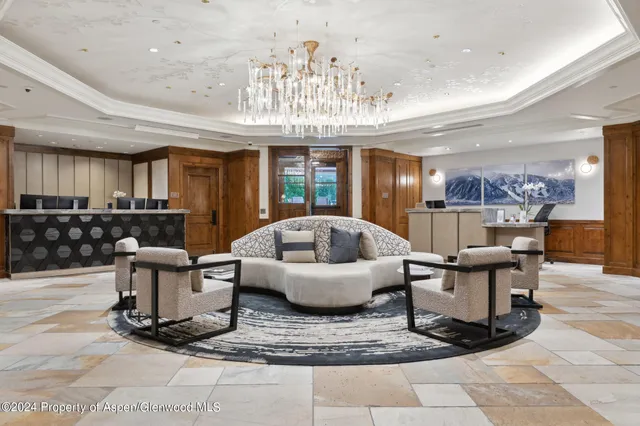 a living room with furniture and a chandelier