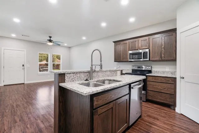 a kitchen with stainless steel appliances granite countertop a sink stove and cabinets