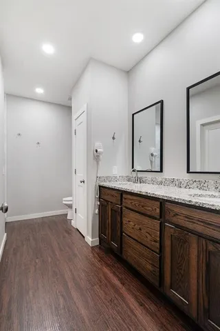 a spacious bathroom with a granite countertop sink and a mirror