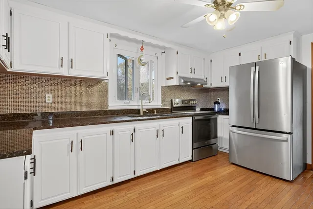 a kitchen with granite countertop white cabinets and white appliances
