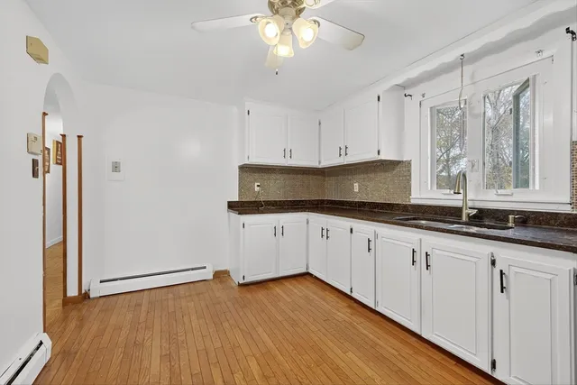 a kitchen with granite countertop white cabinets and white appliances