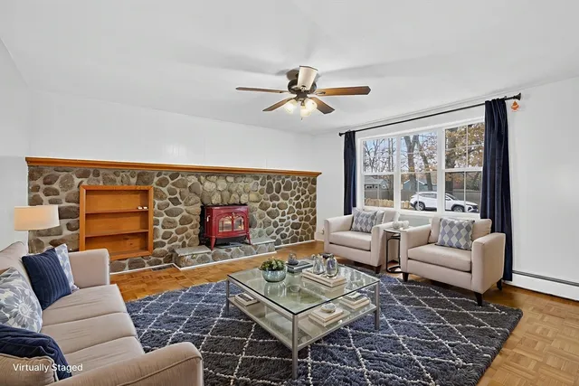 a living room with furniture a flat screen tv and a floor to ceiling window