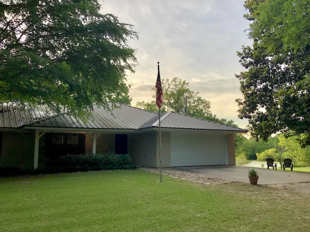 a front view of a house with a garden and yard
