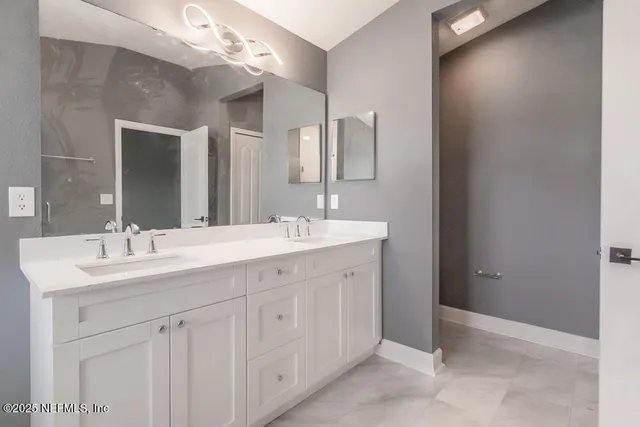 a bathroom with a double vanity sink and a mirror