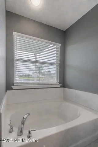 a bath tub sitting in a bathroom next to a window