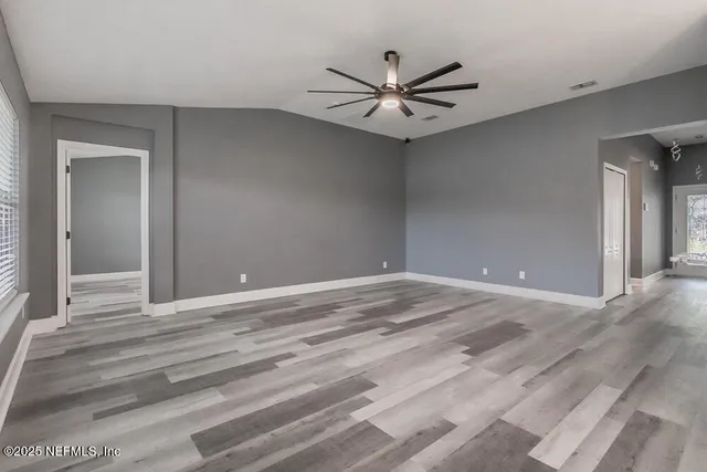 a view of a livingroom with a ceiling fan and wooden floor