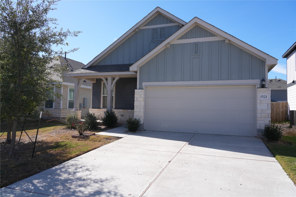 1521 Hope Rnch Road Leander, TX 78641 - Photo 2 of 15 Craftsman-style home with stone siding, board and batten siding, concrete driveway, and an attached garage