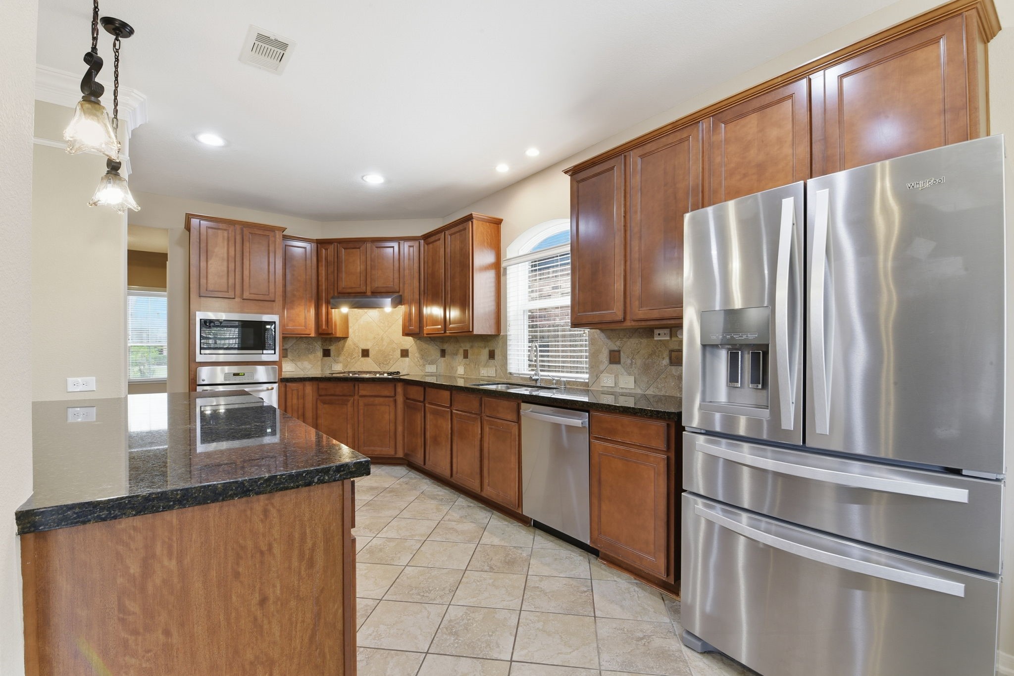 29019 Comal Karst Drive Spring, TX 77386 - Photo 12 of 50 a kitchen with kitchen island granite countertop stainless steel appliances and refrigerator