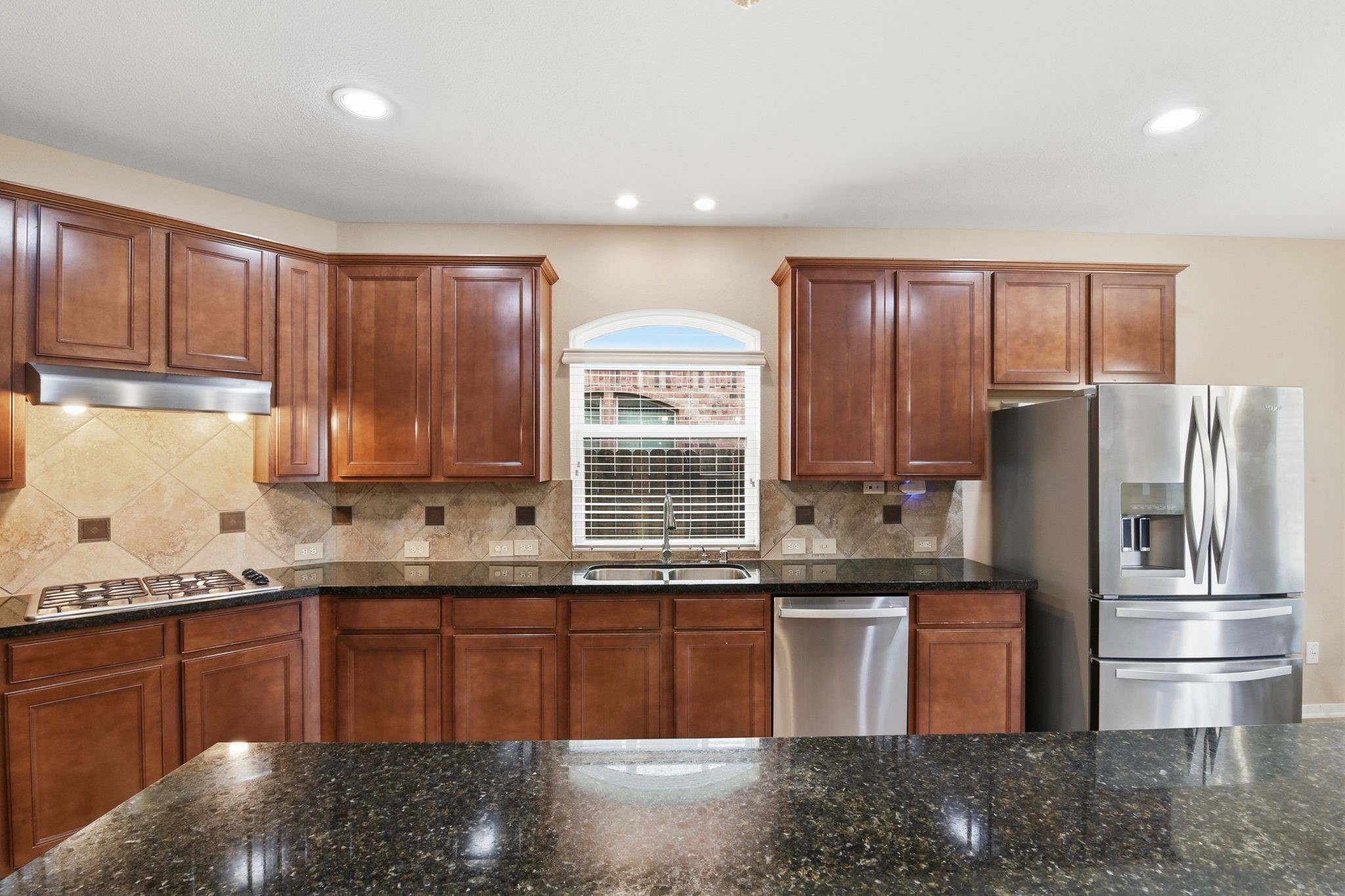 29019 Comal Karst Drive Spring, TX 77386 - Photo 14 of 50 a kitchen with stainless steel appliances granite countertop a sink a stove and a refrigerator