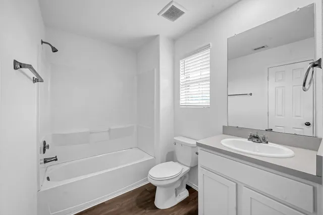a bathroom with a granite countertop toilet a sink and bathtub