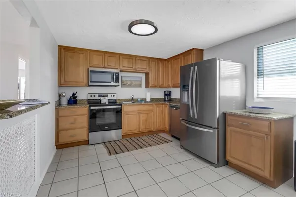 a kitchen with cabinets stainless steel appliances and a window