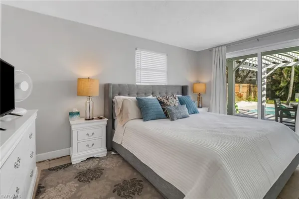 a bedroom with a bed and large windows