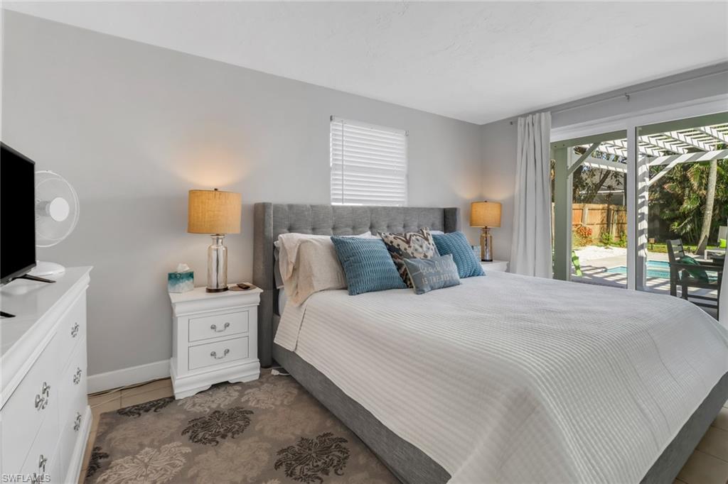 751 100th Avenue North Naples, FL 34108 - Photo 23 of 34 a bedroom with a bed and large windows