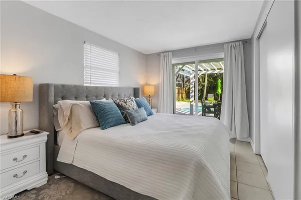 a large bed sitting in a bedroom next to a window