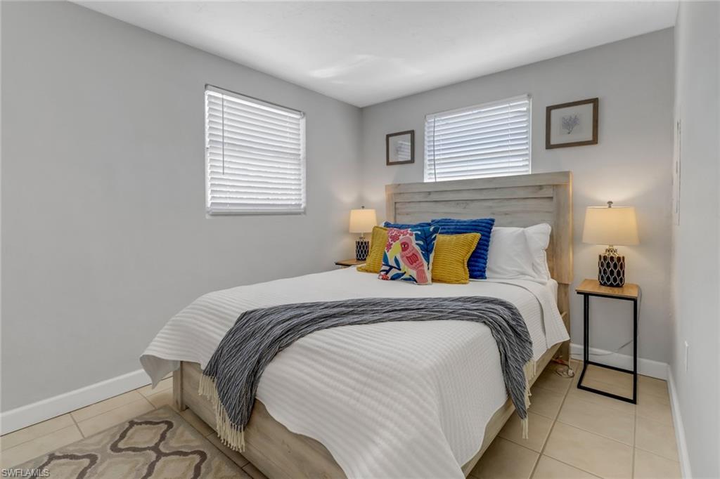 751 100th Avenue North Naples, FL 34108 - Photo 29 of 34 a bed sitting in a bedroom next to a window with a lamp