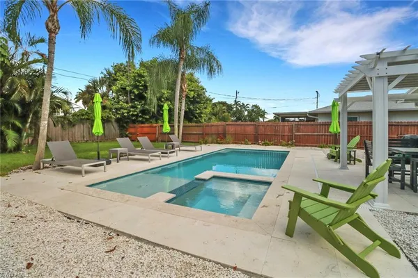 a view of a swimming pool with lounge chairs in patio