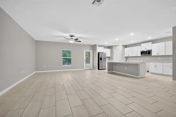 a view of kitchen with granite countertop cabinets and refrigerator