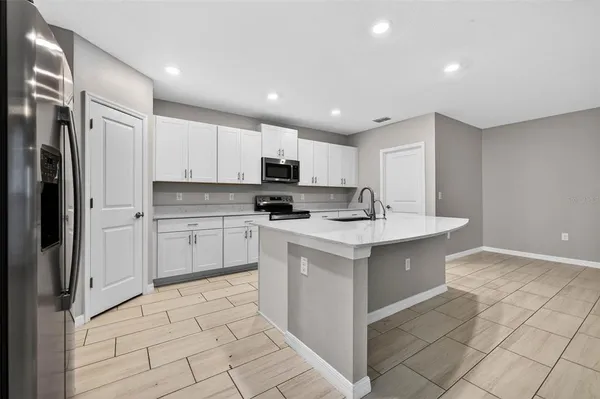 a kitchen with stainless steel appliances a sink stove refrigerator and cabinets