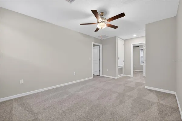 an empty room with closet and fan