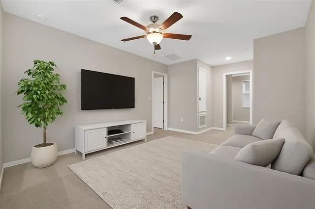 an empty room with ceiling fan and windows