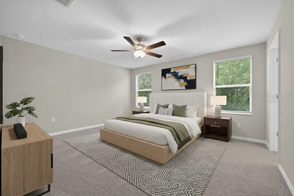 a spacious bedroom with a large bed and a chandelier