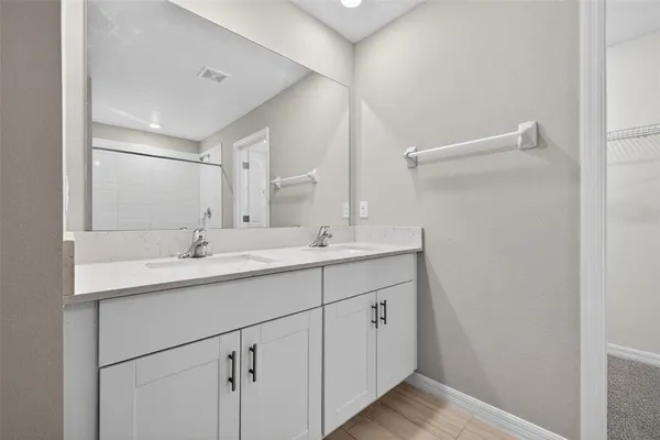 a bathroom with a double vanity sink and mirror
