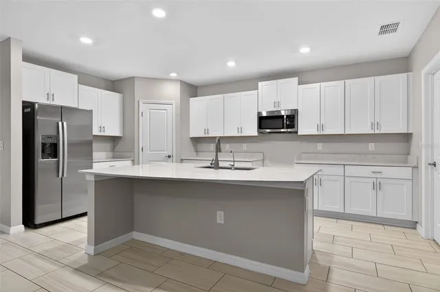 a kitchen with stainless steel appliances granite countertop a refrigerator sink and cabinets