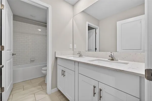 a bathroom with a granite countertop sink a toilet and bathtub