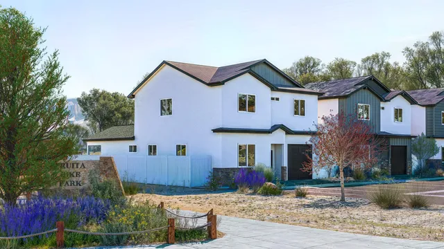 a view of a white house next to a yard with plants and trees