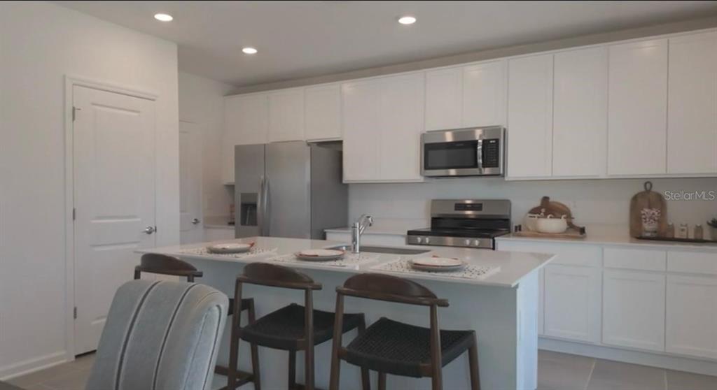 1559 Marksman Road Eagle Lake, FL 33839 - Photo 2 of 17 a kitchen with stainless steel appliances granite countertop a stove a sink a microwave a refrigerator and cabinets