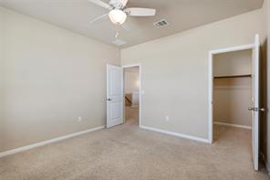 407 Epiphany Lane Pflugerville, TX 78660 - Photo 17 of 29 Unfurnished bedroom featuring a spacious closet, light carpet, and ceiling fan