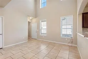 a view of an empty room with window and hardwood floor