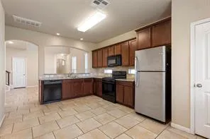 a large kitchen with a refrigerator a stove a sink a microwave and island
