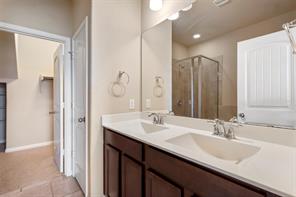 407 Epiphany Lane Pflugerville, TX 78660 - Photo 10 of 29 Full bathroom featuring a stall shower, double vanity, and light tile patterned floors