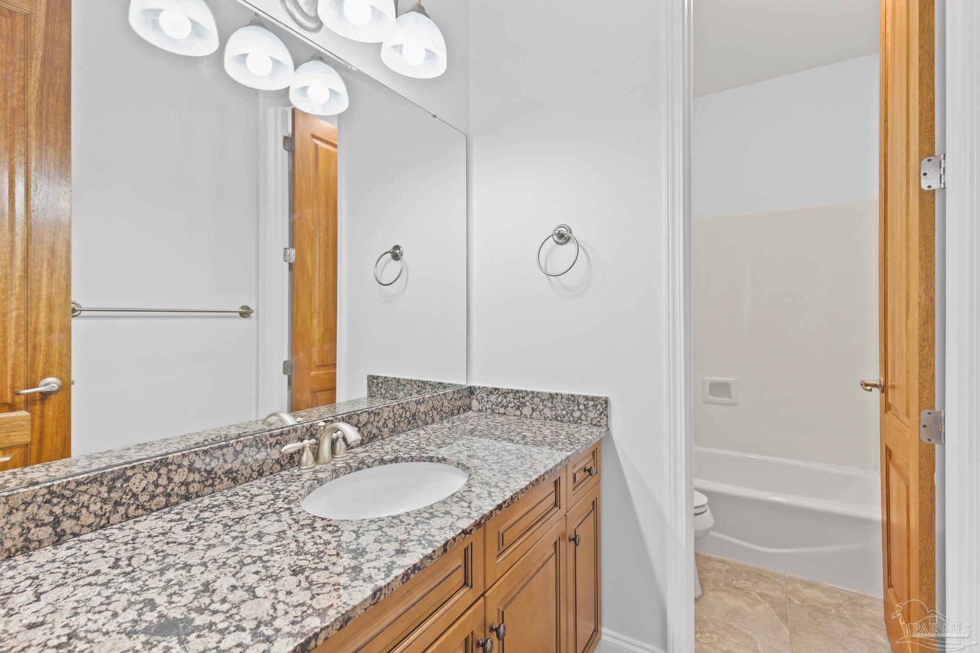 14900 River Road, Unit 904 Perdido Key, FL 32507 - Photo 33 of 62 a bathroom with a granite countertop sink and a mirror