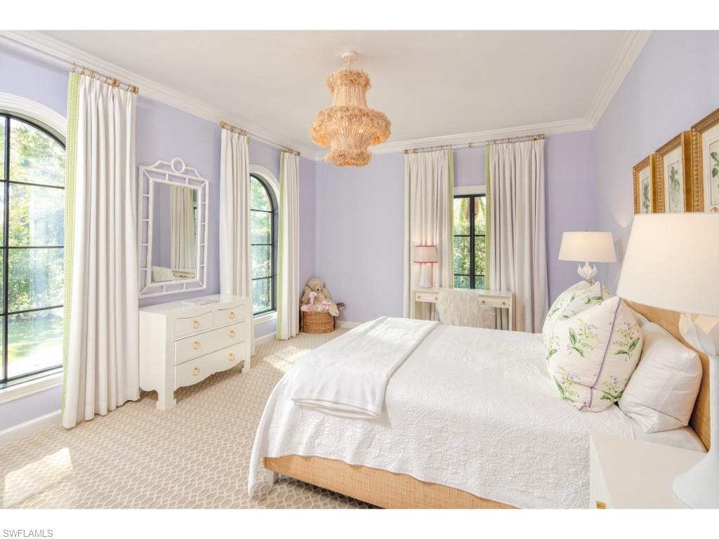 777 Kingstown Drive Naples, FL 34102 - Photo 11 of 18 a bedroom with a bed and a chandelier