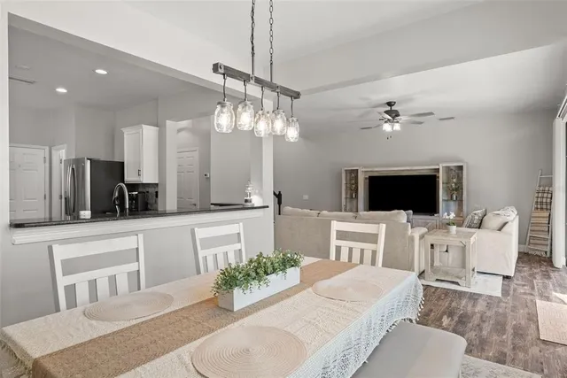 a large kitchen with a center island wooden floor stainless steel appliances and cabinets